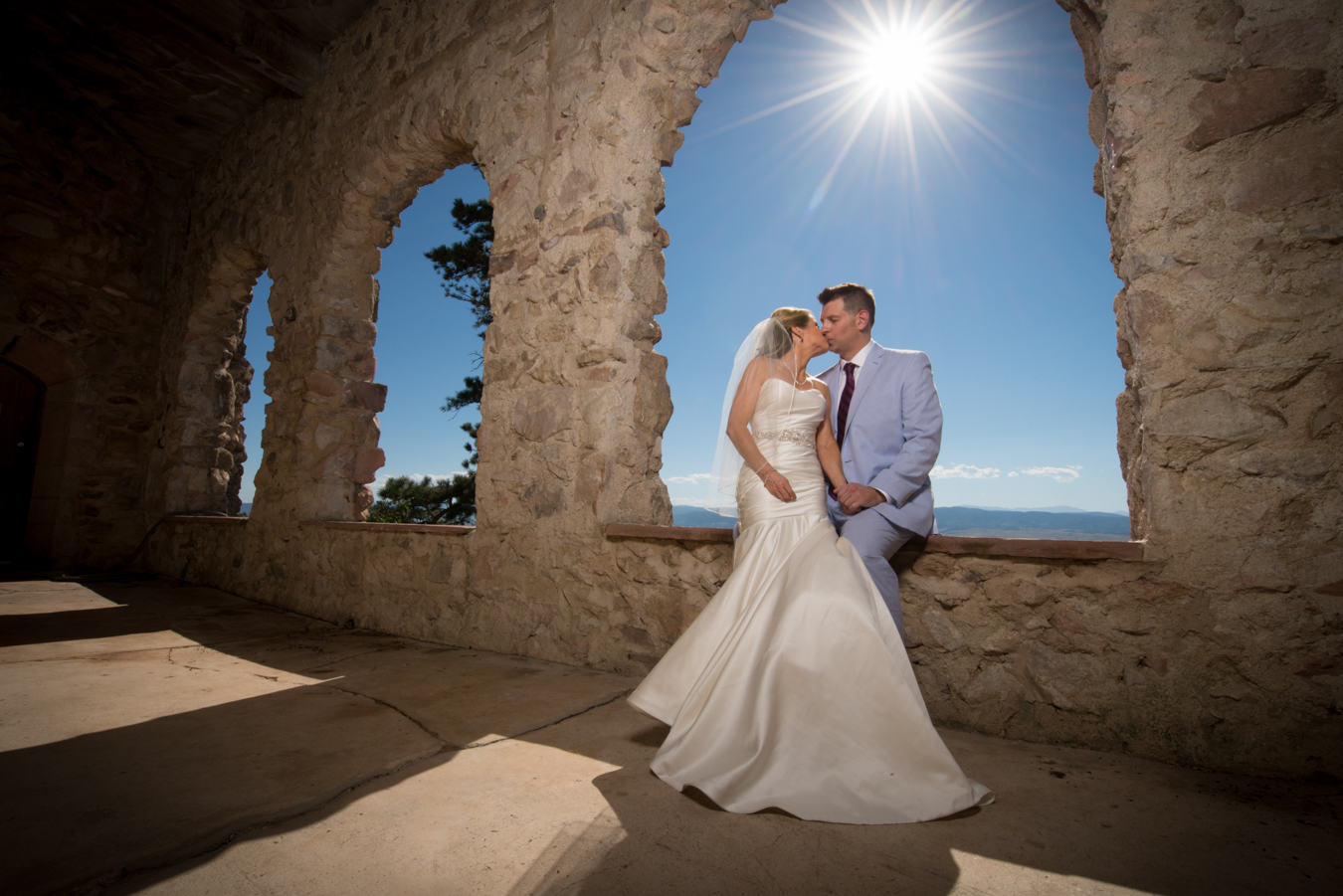 Cherokee Castle and Ranch Wedding Bride Sitting and Grooms Lap Couple  Kissing | Colorado Wedding Photographers | Joe and Robin